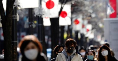 Pedestrians wearing protective masks, amid the coronavirus disease (COVID-19) outbreak, make their way to Ginza shopping district which closed to cars in Tokyo, Japan, Jan. 10, 2021. (Reuters Photo)