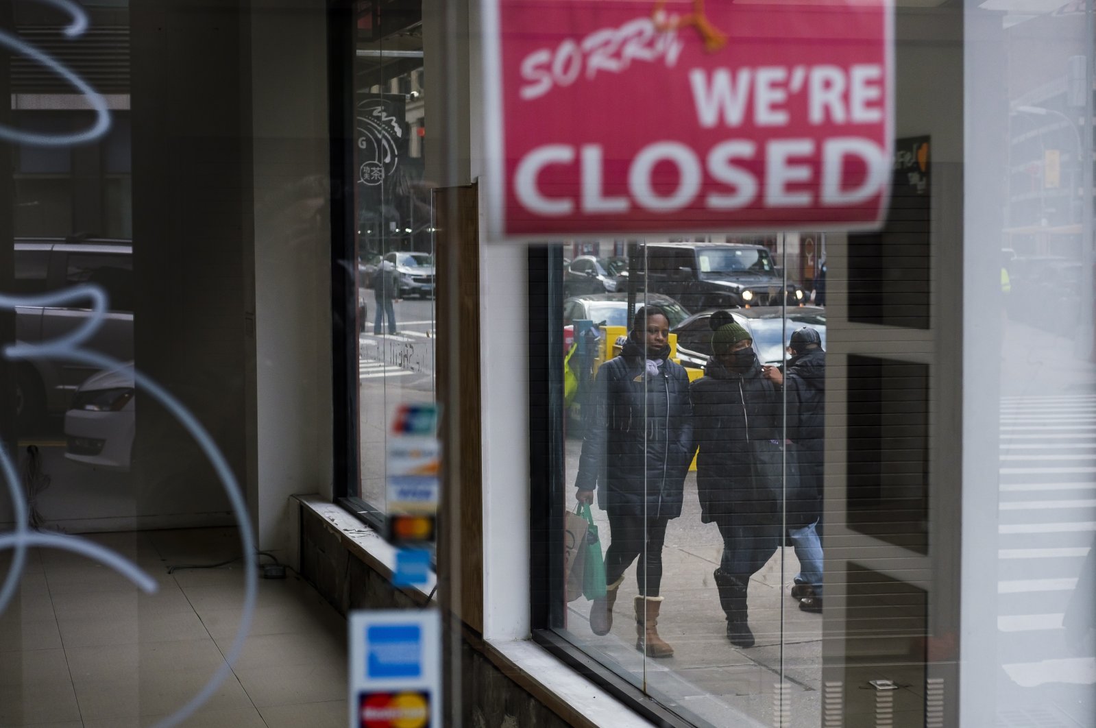 Pedestrians walk past a closed store in New York, New York, USA, on Jan. 8, 2021. (EPA Photo)