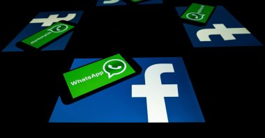 The logo of U.S. social network Facebook and mobile messaging service WhatsApp on the screens of a smartphone and a tablet in Toulouse, southwestern France, Oct. 5, 2020. (AFP Photo)