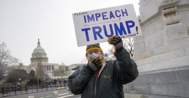 A protester holds a sign that reads "Impeach Trump" near the West Front of the U.S. Capitol in Washington, D.C., Jan. 11, 2021. (EPA Photo)