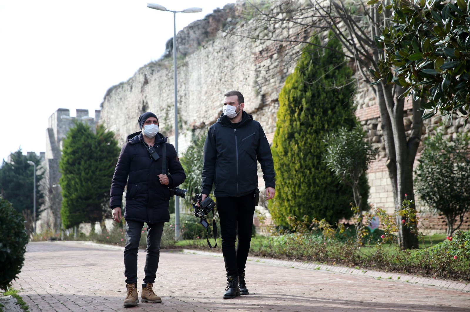 Barış Sözal of Sabah newspaper (L) and Caner Sönmez of IHA, walk near the ancient city walls, in Istanbul, Turkey, Jan. 10, 2021. (AA Photo)