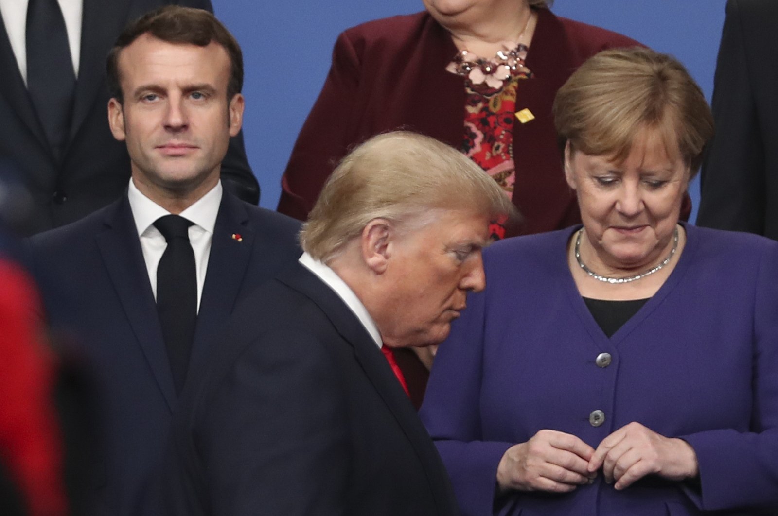 U.S. President Donald Trump (C) walks by French President Emmanuel Macron (L) and German Chancellor Angela Merkel (R) prior to a group photo of NATO leaders during a NATO leaders' meeting at The Grove hotel and resort in Watford, Britain, Dec. 4, 2019. (AP Photo)