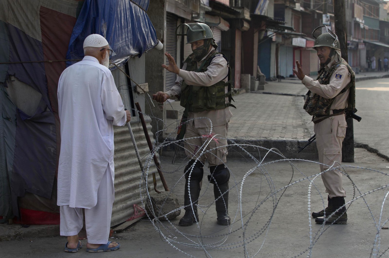 An elderly Kashmiri man is stopped before being allowed to pass near a temporary checkpoint set up by Indian paramilitary soldiers during a lockdown in Srinagar, Indian-administered Kashmir, Aug. 23, 2019. (AP Photo)