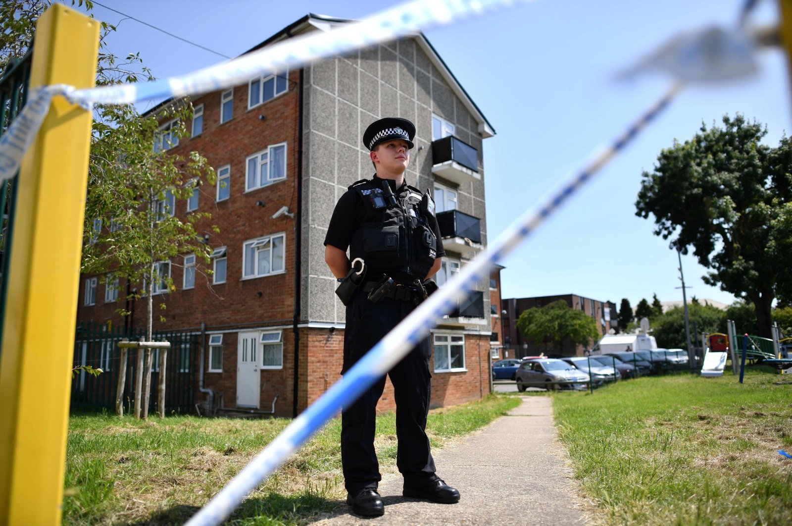 A police officer stands guard outside a cordoned off block of flats where the suspect of a multiple stabbing incident lived in Reading, west of London, June 23, 2020. (AFP)