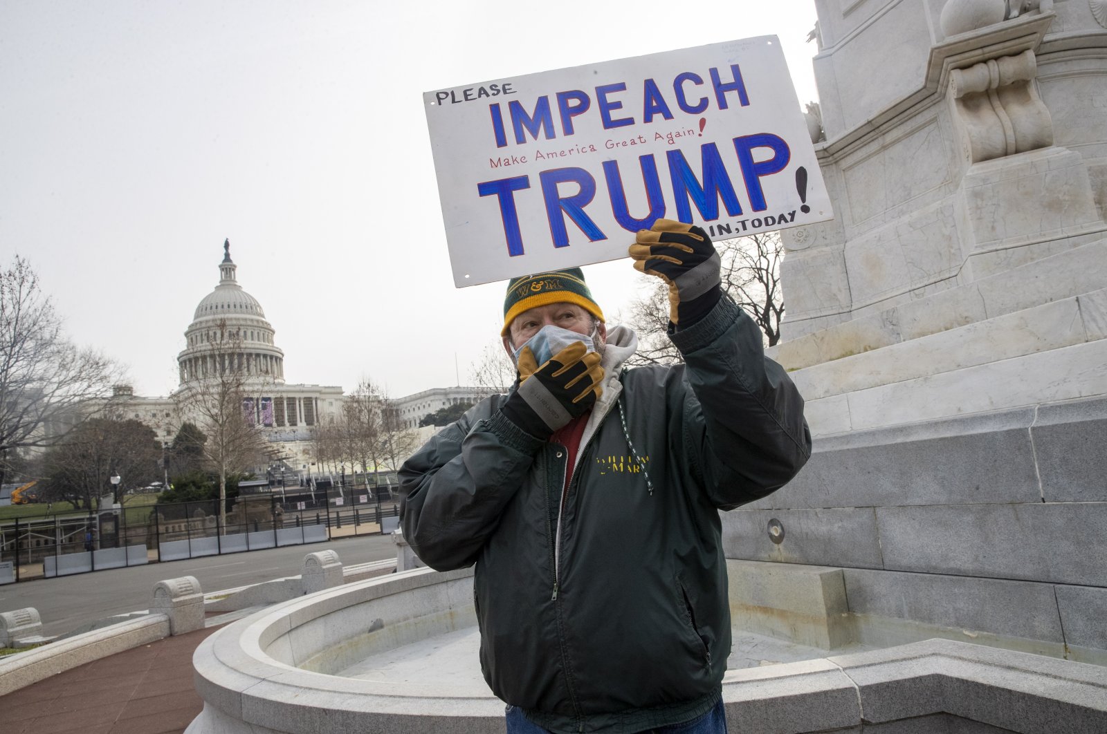 A protester holds a sign that reads "Impeach Trump" near the West Front of the U.S. Capitol in Washington, D.C., Jan. 11, 2021. (EPA Photo)
