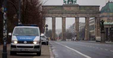 A police vehicle is seen at a virtually empty 17th of June street boulevard leading up to landmark Brandenburger Gate in Berlin, on Jan. 5, 2021. (AFP Photo)
