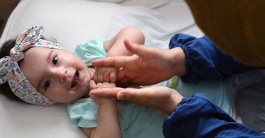 Sare Aras, a 1-year-old SMA patient, plays with her mother in their home, in Istanbul, Turkey, Sept. 5, 2020. (AA Photo)