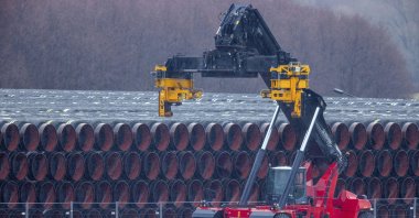 A special vehicle used to transport pipes for the Nord Stream 2 natural gas pipeline stands next to pipes at a storage yard in the port of Mukran in Sassnitz on the island of Ruegen, Germany on Jan. 6, 2021. (AP Photo)