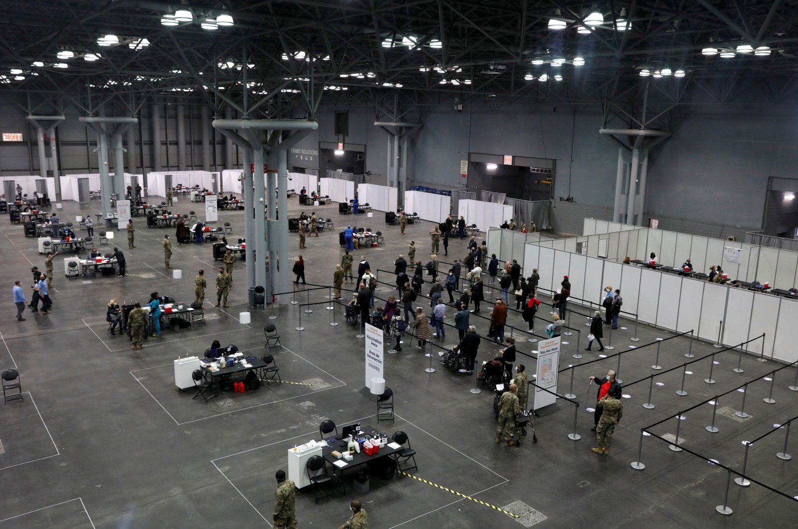People line up as health care workers and military personnel work to distribute doses of the coronavirus disease (COVID-19) vaccine at the New York State COVID-19 vaccination site at the Jacob K. Javits Convention Center, in New York City, U.S., January 13, 2021. (Reuters Photo)
