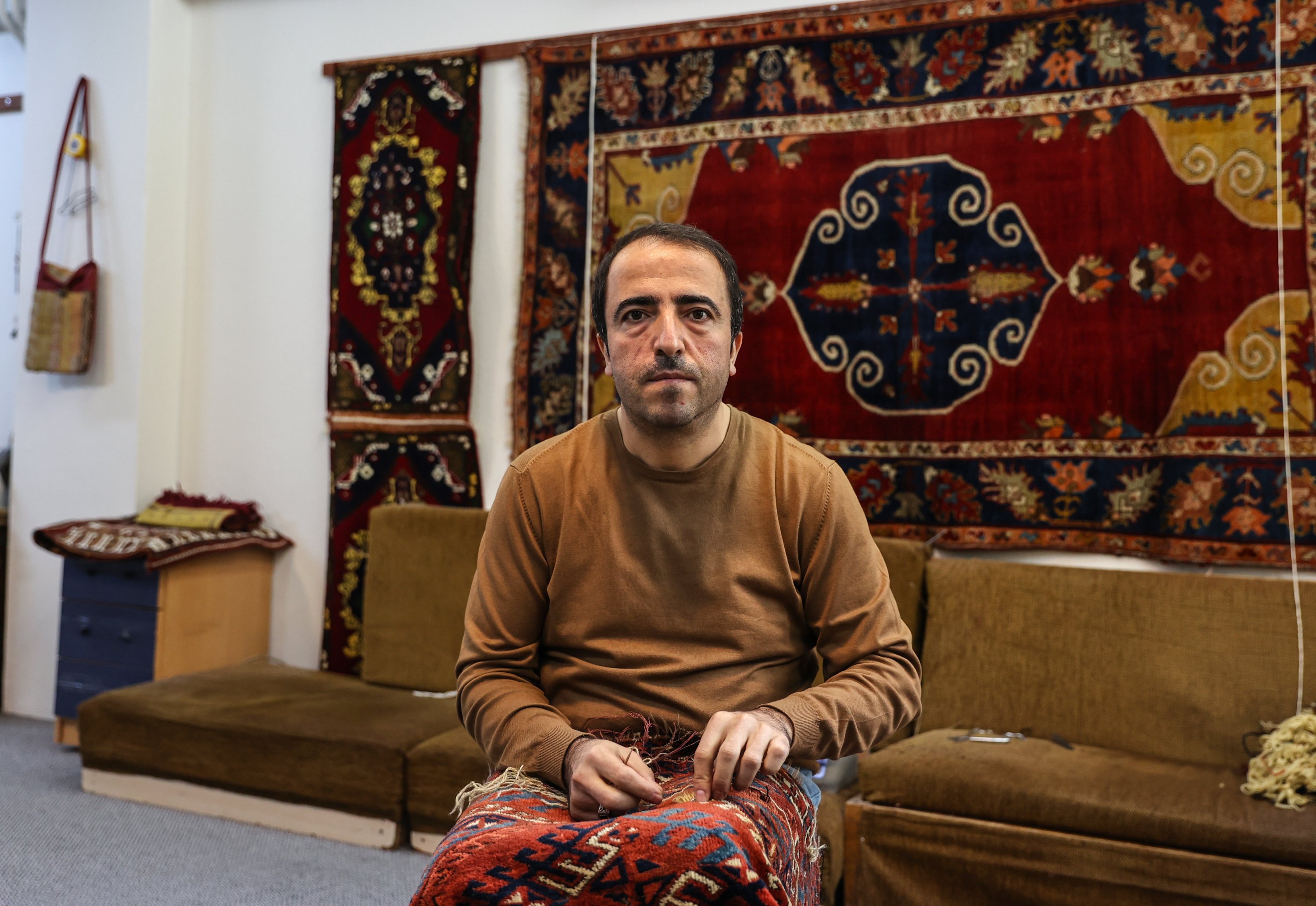 Ramazan Yumuşak repairs a traditional carpet at his workshop in the Babıali Carpetmakers Bazaar, Istanbul, Turkey, Jan. 10, 2021. (AA Photo)