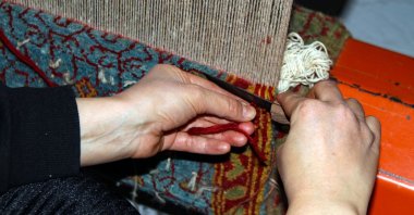 A close-up of the hands of a local woman weaving a carpet at the workshop in Iğdır, eastern Turkey, Jan. 13, 2021. (AA Photo)