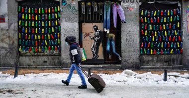A man walks with a suitcase on a snow-covered street in the center of Madrid, Spain, Jan. 13, 2021. (Reuters Photo)