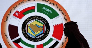 A Saudi television anchor stands in front of the logo of the 41st Gulf Cooperation Council (GCC) at the media center in Al Ula, Saudi Arabia, Jan. 5, 2021. (AP Photo)