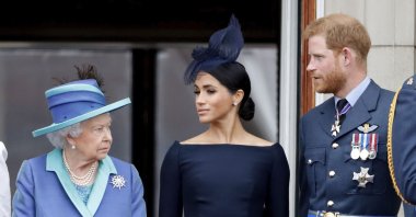 Queen Elizabeth II, Meghan, Duchess of Sussex and Prince Harry, Duke of Sussex watch a flypast to mark the centenary of the Royal Air Force from the balcony of Buckingham Palace, London, July 10, 2018. (Getty Images)
