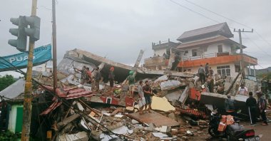 Residents inspect earthquake-damaged buildings in Mamuju, West Sulawesi, Indonesia, Jan. 15, 2021. (AP Photo)