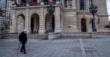An elderly man with a face mask passes the Old Opera in Frankfurt, Germany, Jan. 14, 2021. (AP Photo)