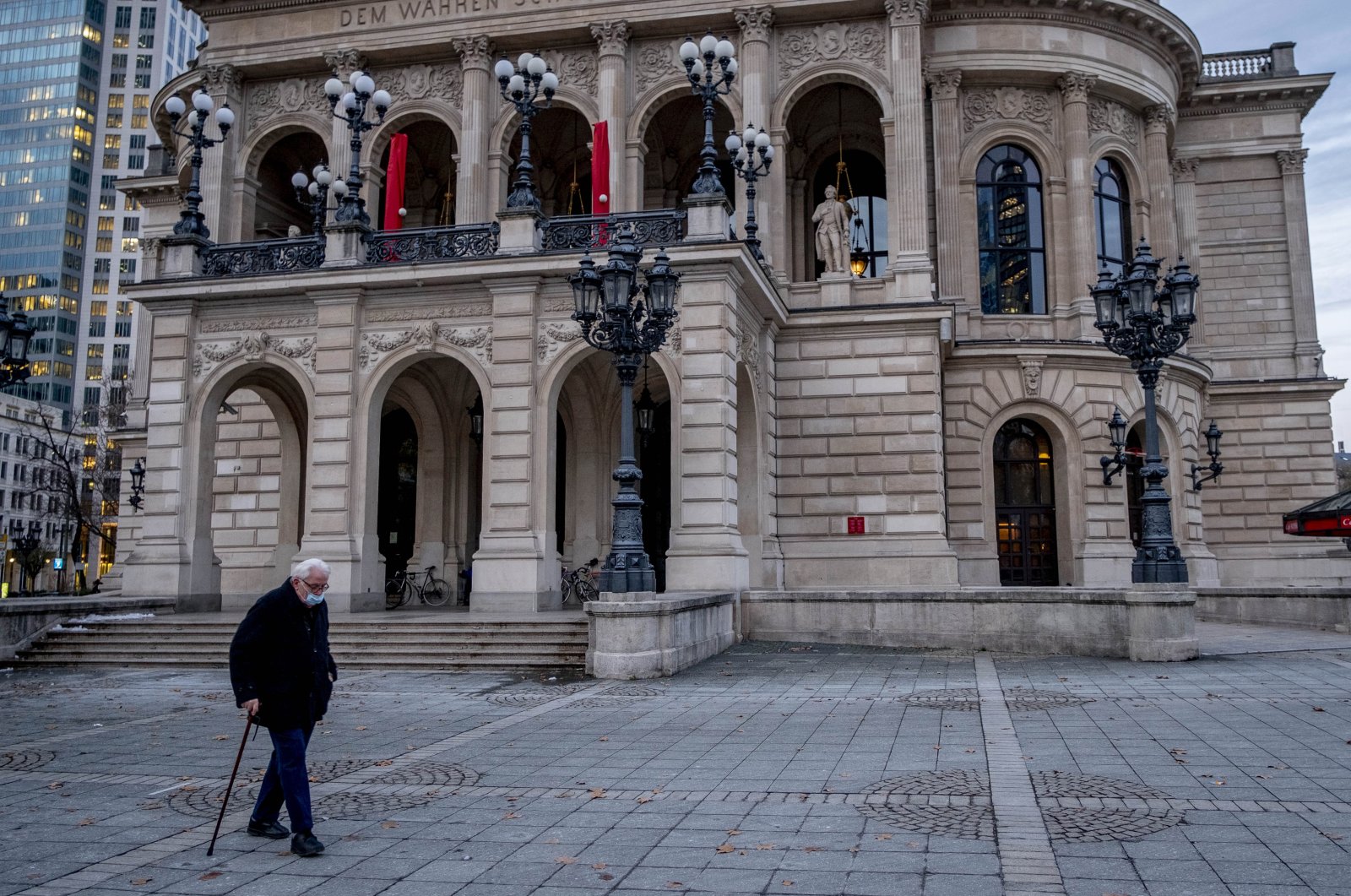 An elderly man with a face mask passes the Old Opera in Frankfurt, Germany, Jan. 14, 2021. (AP Photo)