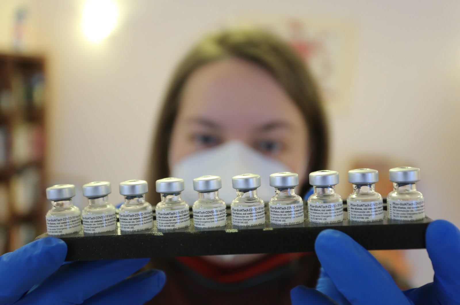 A member of a mobile vaccination team holds a tray of doses of the BioNtech-Pfizer vaccine in Halberstadt, Germany, Friday, Jan.15, 2021. (AP Photo)