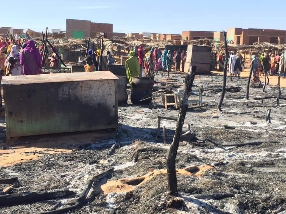 Residents of a refugee camp gather around the burned remains of makeshift structures, in Genena, Sudan, Dec. 29, 2019. (Photo by the Organization for the General Coordination of Camps for Displaced and Refugees via AP)