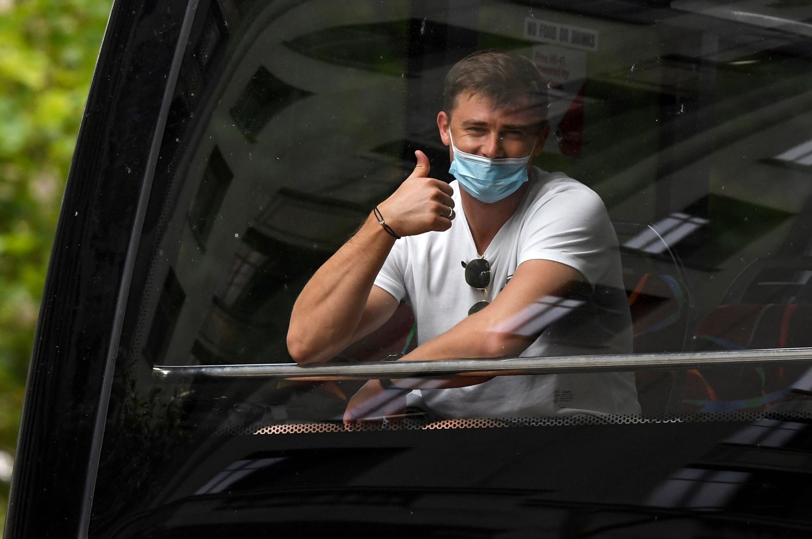 A man gestures as tennis players, coaches and officials arrive at a hotel before quarantining for two weeks ahead of the Australian Open tennis tournament in Melbourne, Jan. 15, 2021. (AFP Photo)