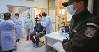 A Romanian gendarme waits to get a COVID-19 vaccine at a hospital in Bucharest, Romania, Jan. 15, 2021. (AP Photo)