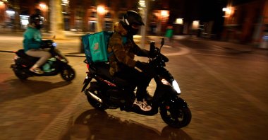 A Deliveroo food delivery scooter drives through a deserted Place Saint Pierre in Toulouse, France, Jan. 16, 2021. (AFP Photo)