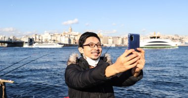 Yoshi Enomoto takes a selfie by the Bosporus, in Istanbul, Turkey, Jan. 17, 2021. (AA PHOTO)