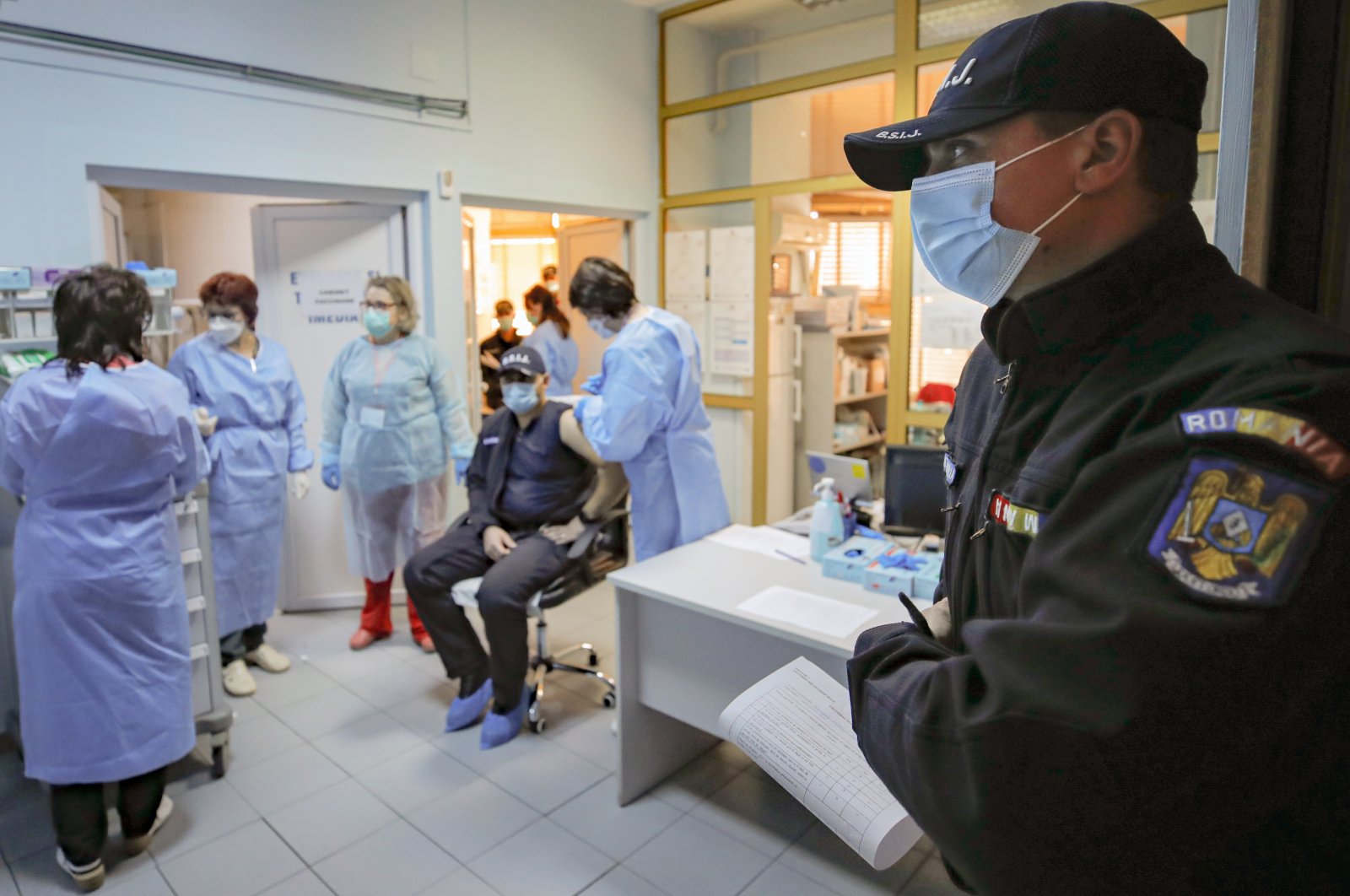 A Romanian gendarme waits to get a COVID-19 vaccine at a hospital in Bucharest, Romania, Jan. 15, 2021. (AP Photo)