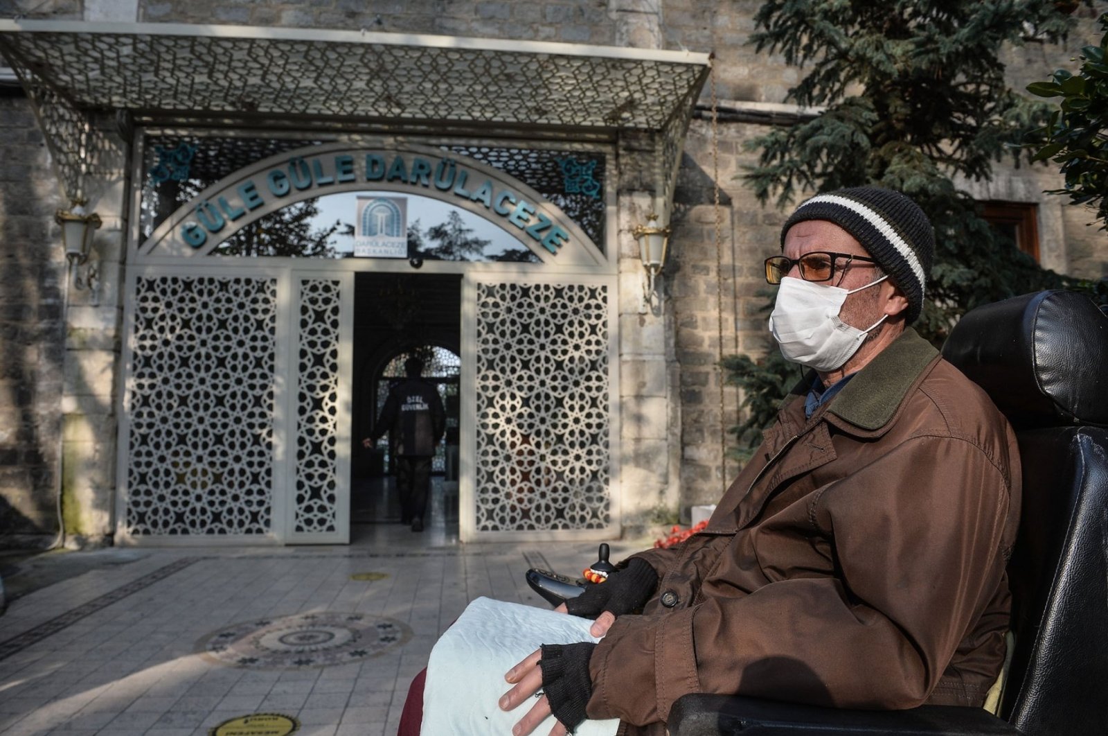A resident sits in his wheelchair in front of the door of Darülaceze nursing home, in Istanbul, Turkey, Dec. 1, 2020. (DHA PHOTO)