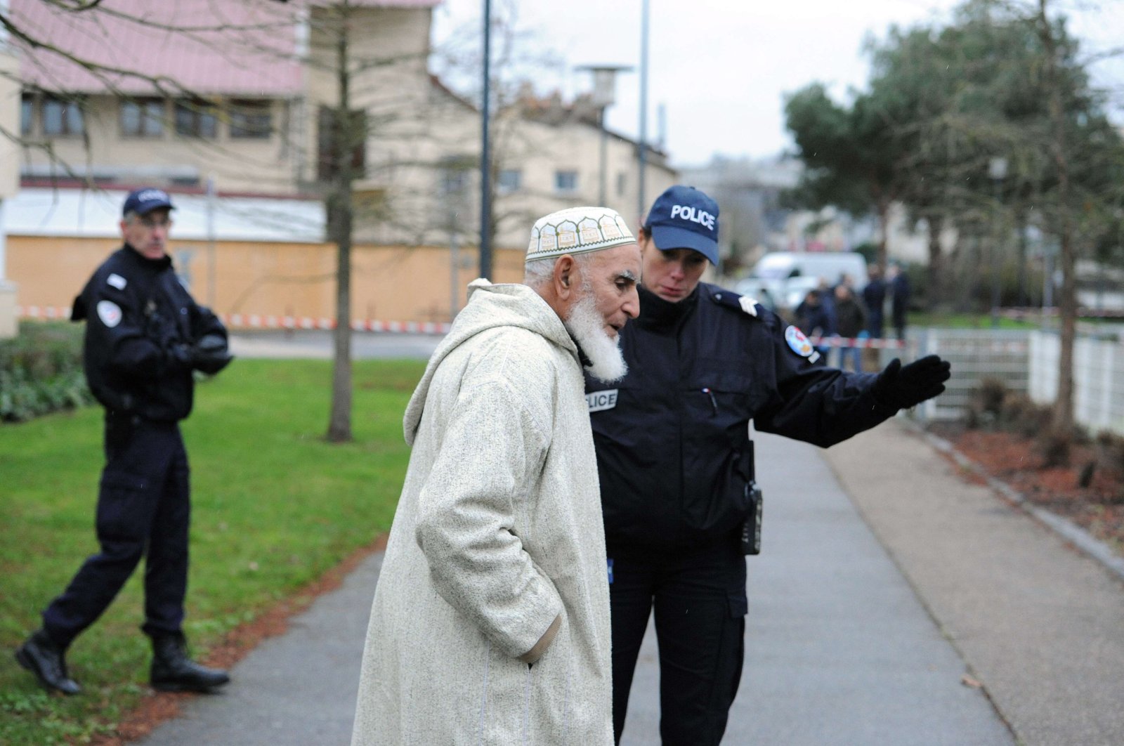 A police officer directs a man away as members of the French technical and scientific police work at the site near a mosque in the Sablons neighborhood of Le Mans, western France, Jan. 8, 2015. (AFP Photo)