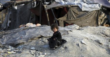 An internally displaced girl poses for a photograph outside her temporary home in the city of Kabul, Afghanistan, Jan. 18, 2021. (AP Photo)