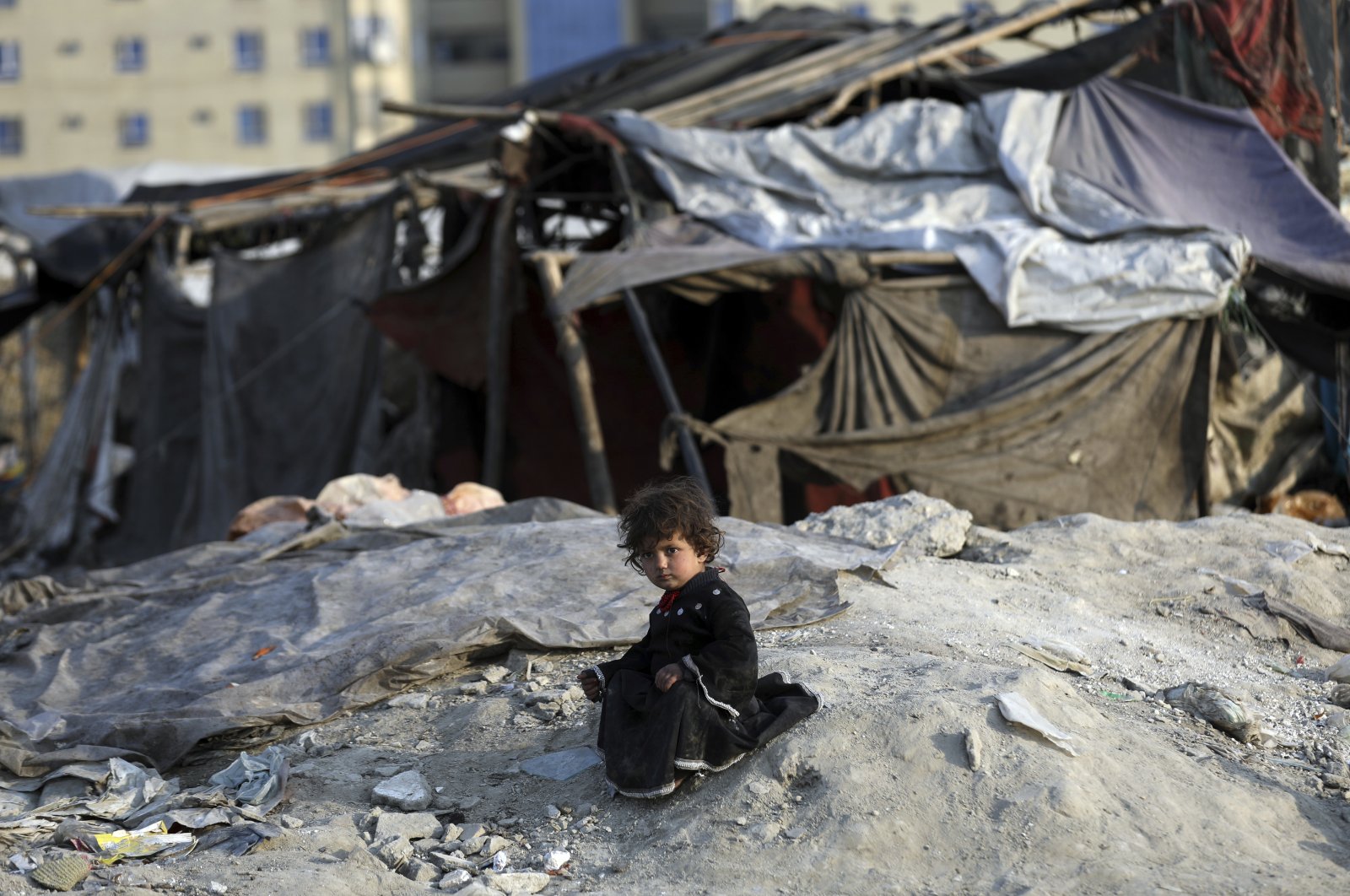 An internally displaced girl poses for a photograph outside her temporary home in the city of Kabul, Afghanistan, Jan. 18, 2021. (AP Photo)