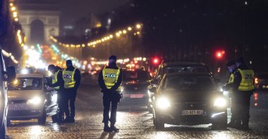 French police officers man a checkpoint on the Champs-Elysees to check drivers' authorizations to be outdoors after the 6 p.m. curfew, in Paris, France, Jan. 16, 2021. (EPA Photo)