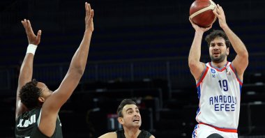 Anadolu Efes' Buğrahan Tuncer (R) attempts a shot against Bursaspor in the ING Basketball Süper Lig match, at the Sinan Erdem Sports Center, Istanbul, Turkey, Jan. 19, 2021.