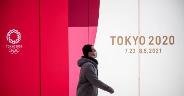 A man walks past Tokyo 2020 Olympic and Paralympic Games advertising in Tokyo's Shinjuku district, Japan, Jan. 20, 2021. (AFP Photo)