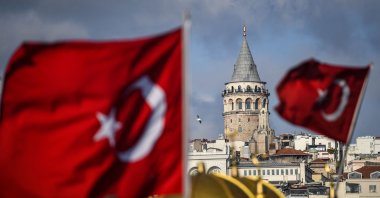 The Galata Tower seen behind Turkish national flags during a curfew against the spread of the coronavirus, Istanbul, Turkey, Dec. 6, 2020. (AFP Photo)