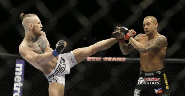 Conor McGregor (L) kicks Dustin Poirier during their mixed martial arts bout in Las Vegas, Nevada, Sept. 27, 2014. 
McGregor returns from a year-long layoff for a rematch against Poirier in the promotions' first pay-per-view of the year, at UFC 257 on Jan. 24 in Abu Dhabi. (AP Photo)
