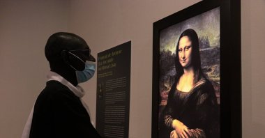 A man inspects the painting "Mona Lisa" by Leonardo da Vinci during "Opera Omnia Leonardo" exhibition, Dakar, Senegal, Jan. 22, 2021. (AA Photo)