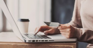 A woman enters her credit card details for an online transaction. (Shutterstock Photo)