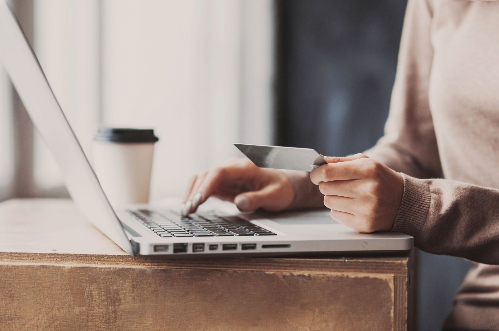 A woman enters her credit card details for an online transaction. (Shutterstock Photo)