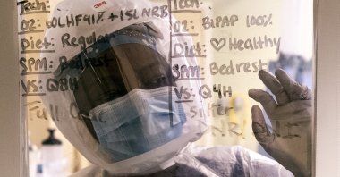 Nurse Ann Lawani looks through the window of a COVID-19 patient's room in the ICU, San Diego, California, U.S., Jan. 20, 2021. (EPA-EFE Photo)