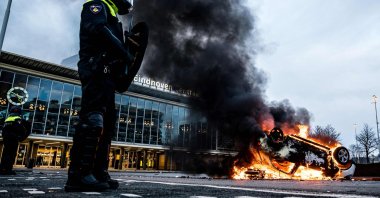 A car is set on fire in front of the train station after a rally by several hundreds of people against the coronavirus policies, in Eindhoven, the Netherlands, Jan. 24, 2021. (AFP Photo)