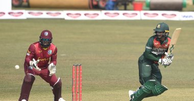 West Indies' wicketkeeper Jahmar Hamilton (L) looks on as Bangladesh's Shakib Al Hasan (R) plays a shot during the third and final one-day international (ODI) at the Zohur Ahmed Chowdhury Stadium, Chattogram, Bangladesh, Jan. 25, 2021. (AFP Photo)