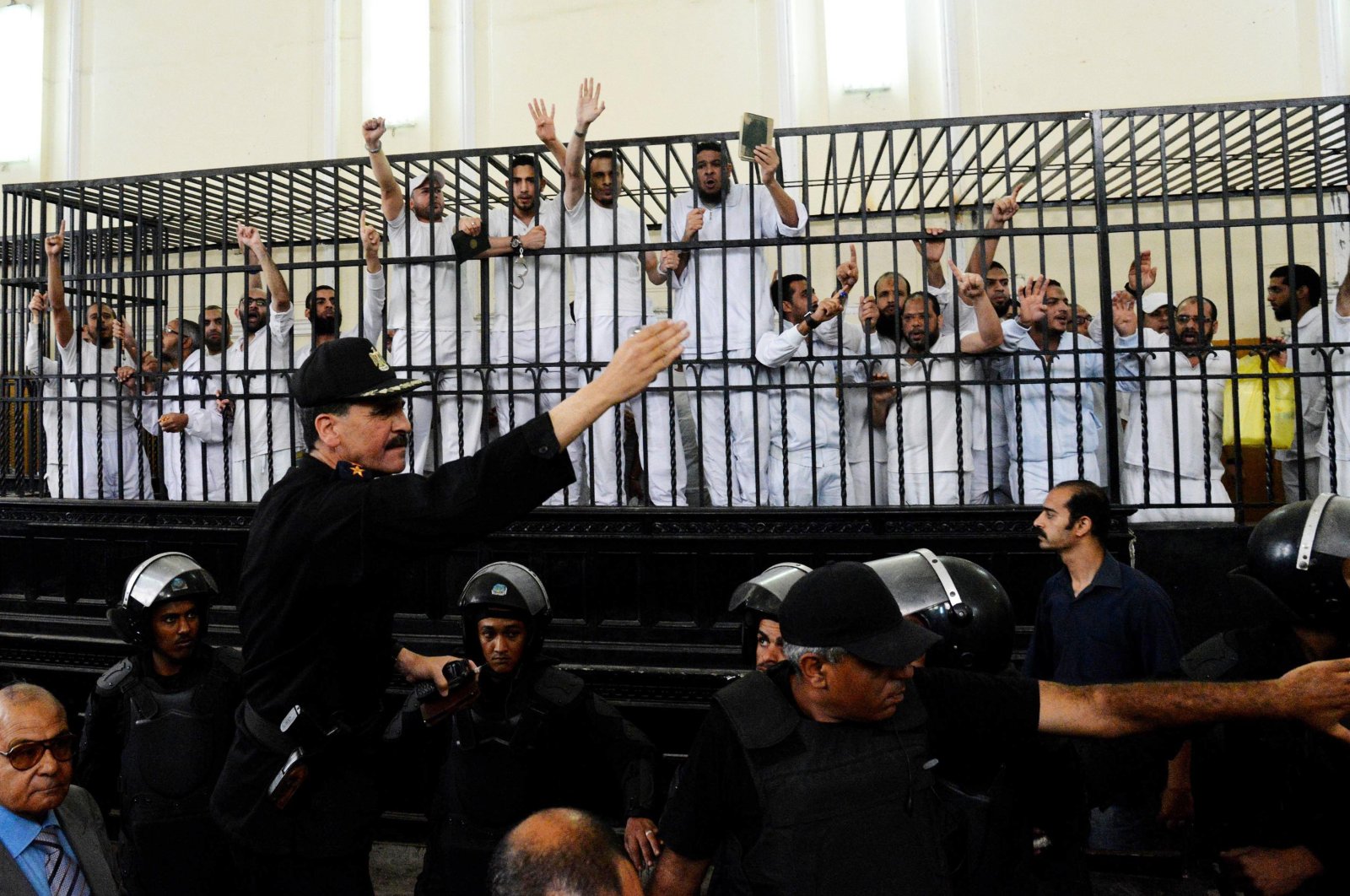 Supporters of the Muslim Brotherhood gesture from the defendants cage as they receive sentences in a mass trial in Alexandria, Egypt, May 19, 2014. (AP Photo)