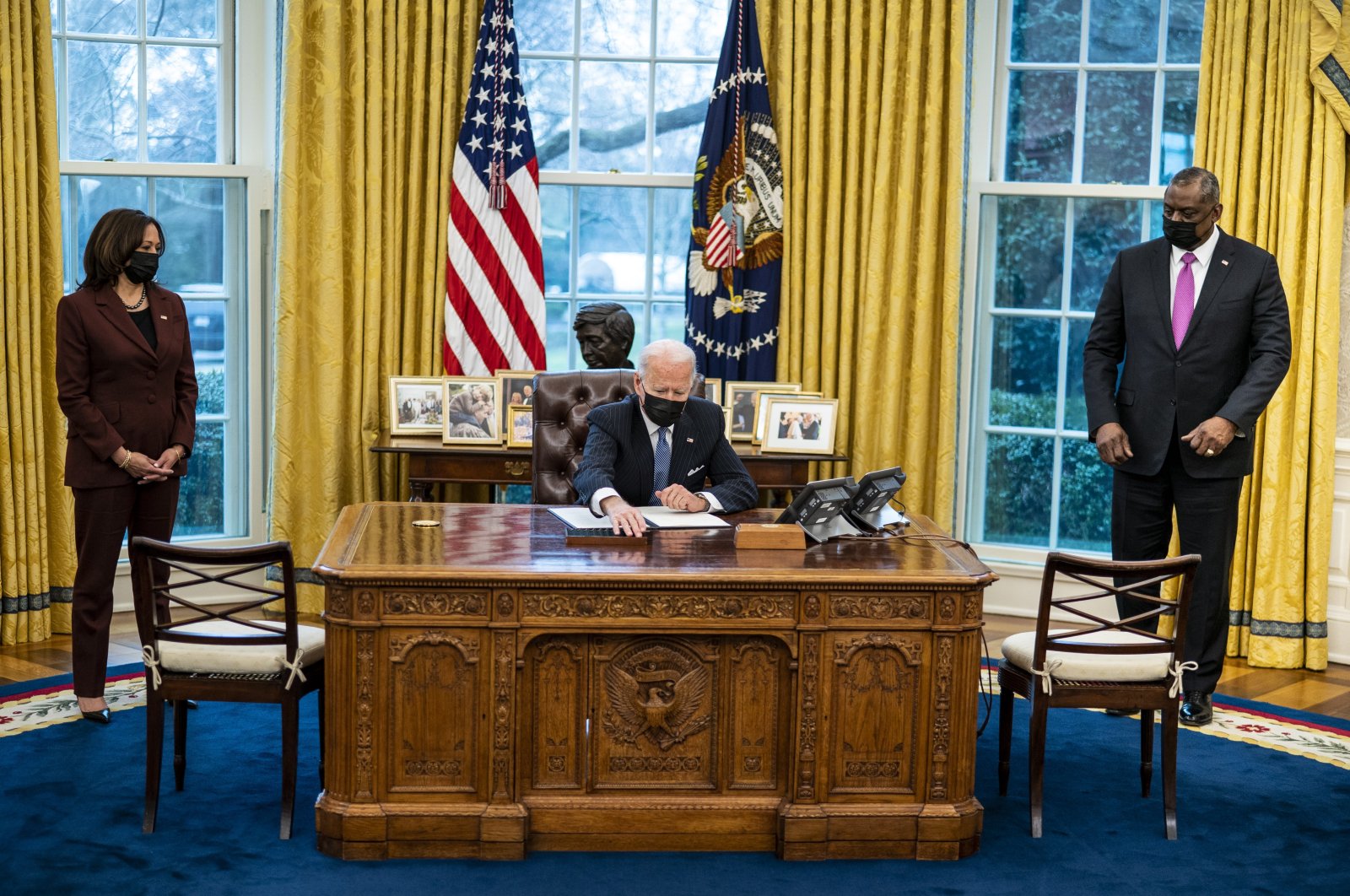 US President Joe Biden signs executive action with Vice President Kamala Harris and Secretary of Defense Gen. Lloyd Austin, in the Oval Office at the White House, in Washington, D.C., U.S., Jan. 25, 2021. (EPA Photo)