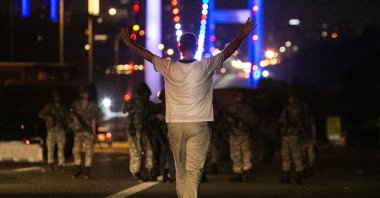 A man resists FETÖ-linked soldiers with his hands up at the entrance to the Bosphorus Bridge during the night of coup attempt, Istanbul, Turkey, July 16, 2016. (AFP Photo)
