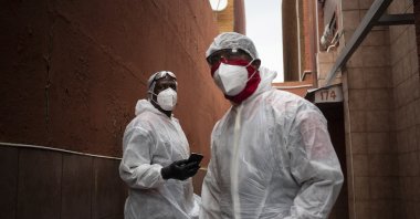 Paramedics Michael Makhethe (L) and Clive Moleso, working for the Saaberie Chishty ambulance service, stand outside the house of a COVID-19 patient in Lenasia, South Africa, Jan. 7, 2021. (AP Photo)