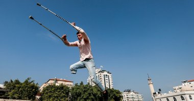 Mohamed Aliwa, a Palestinian youth whose leg was amputated near the knee in 2018 after he was hit by Israeli army fire during protests along the fortified border separating the Gaza Strip from Israel, shows off his parkour skills despite his disability and while on crutches in Gaza City, Jan. 4, 2021. (AFP Photo)