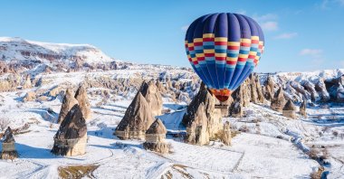 Going on a hot air balloon ride over snowy mountains in Cappadocia is a magical experience. (Shutterstock Photo)