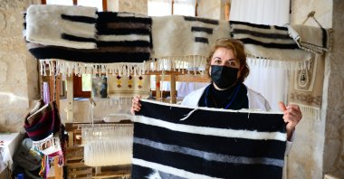 Master trainer Gülhayat Acabey shows a rug in front of a loom at the Mardin Technical Institute, Mardin, southeastern Turkey, Jan. 28, 2020. (AA Photo)